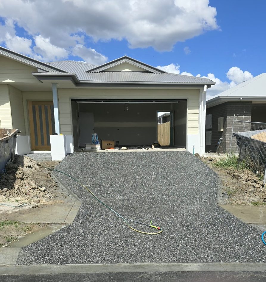 Charcoal exposed aggregate driveway with white fleck at a double garage