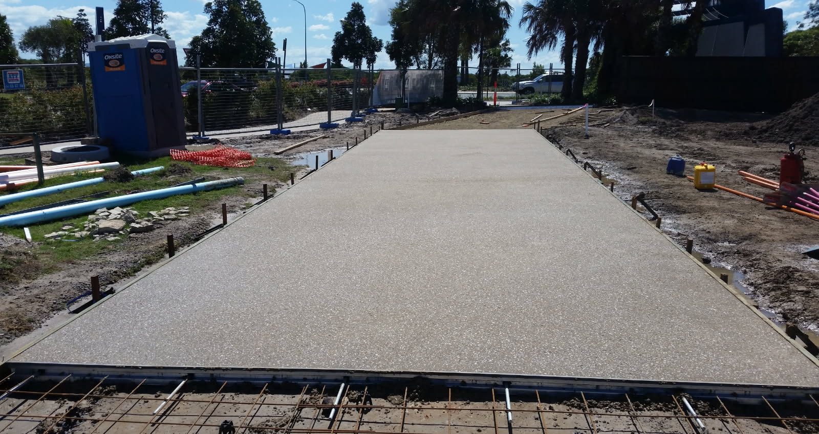 Freshly washed exposed aggregate slab with formwork and steel mesh in the foreground